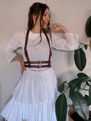 A girl dressed in a dress with a Kristal harness.